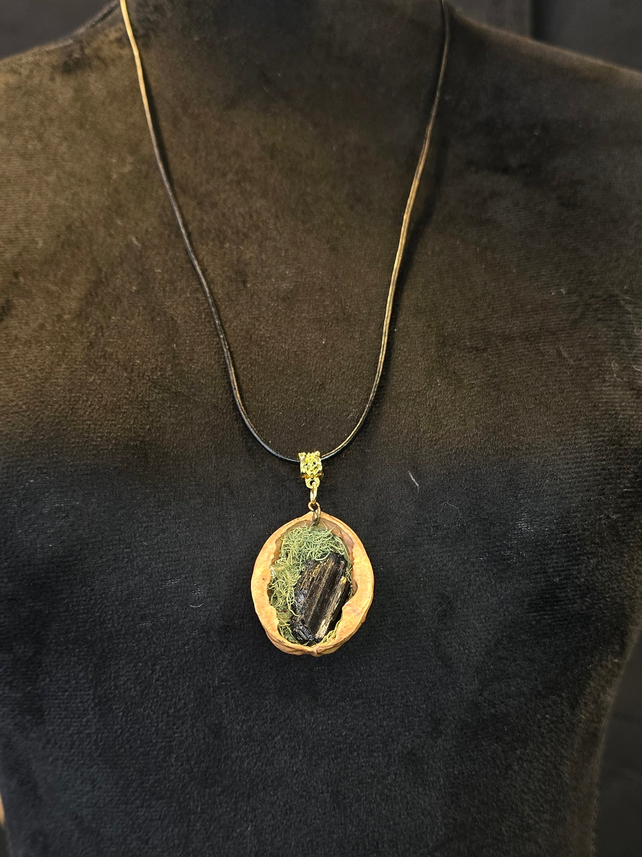 Kaulakoru, joka on valmistettu saksanpähkinän kuoresta, sammaleesta ja turmaliinista. 