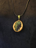 Kaulakoru, joka on valmistettu saksanpähkinän kuoresta, sammaleesta ja turmaliinista. 