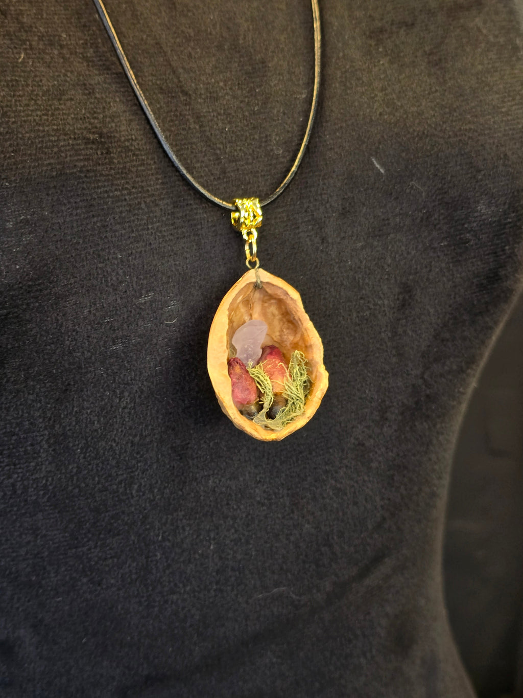 Kaulakoru valmistettu saksanpähkinäkuoresta, jossa sammalta, ruusukvartsia ja ruusunnuppuja.