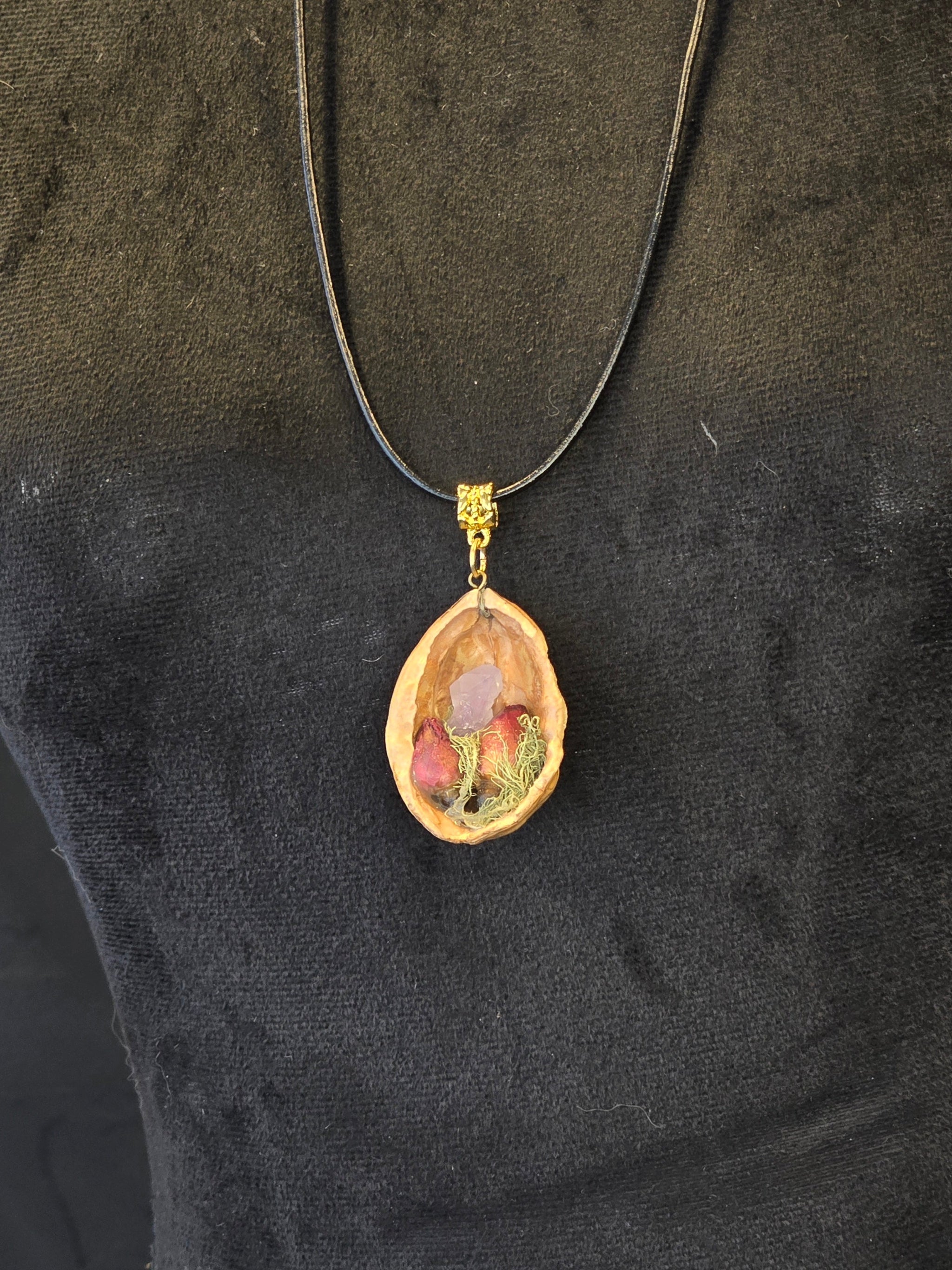 Kaulakoru valmistettu saksanpähkinäkuoresta, jossa sammalta, ruusukvartsia ja ruusunnuppuja.