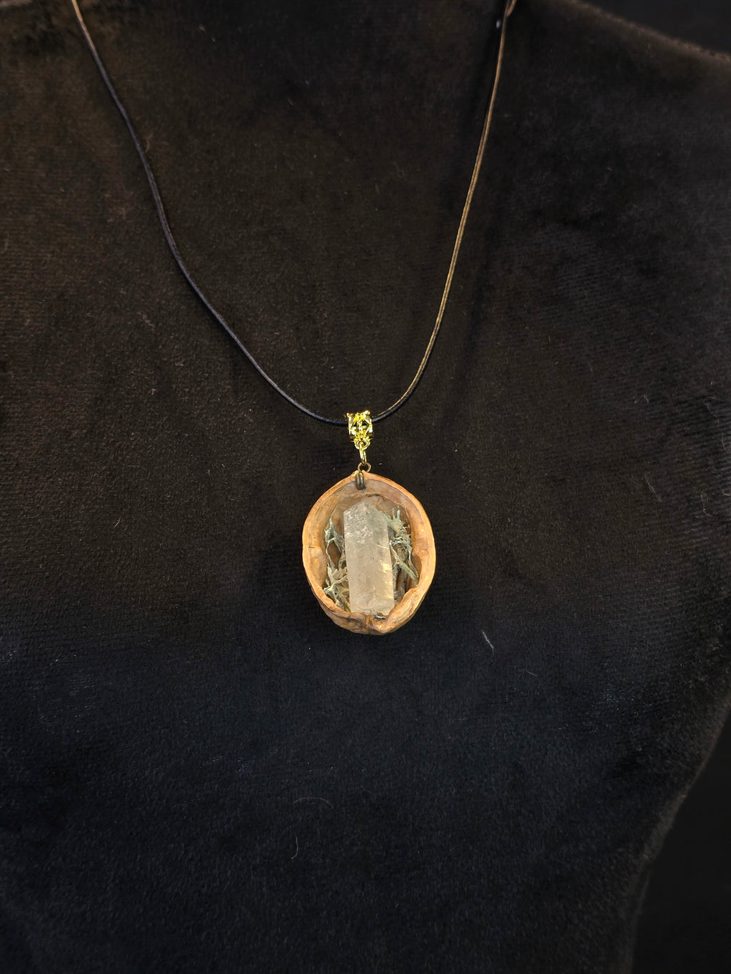 Kaulakoru, joka on valmistettu saksanpähkinänkuoresta, jäkälästä ja vuorikristallista. 