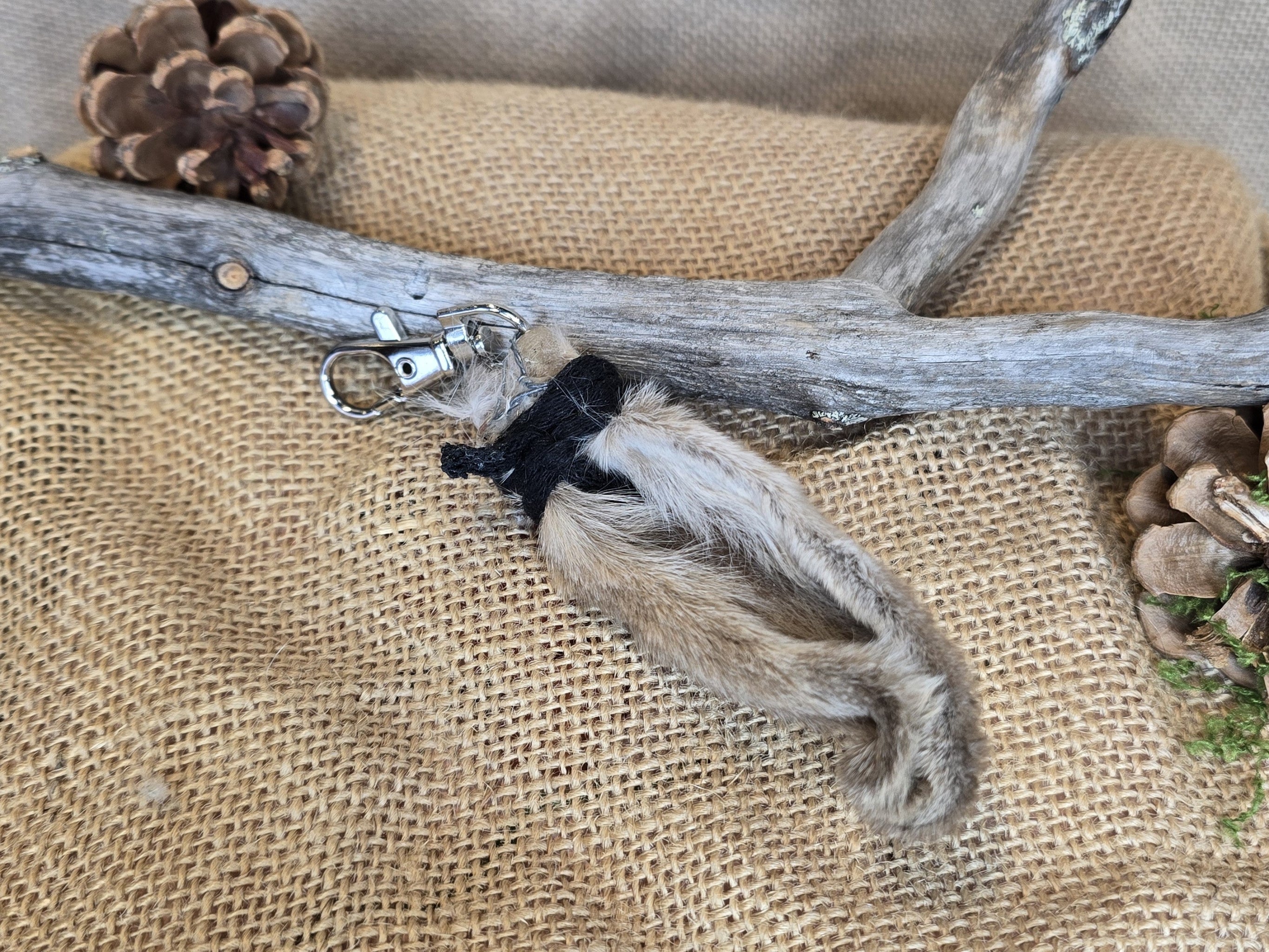 Pupunkorva laukkukoru tai avaimenperä, somisteena musta nauha.