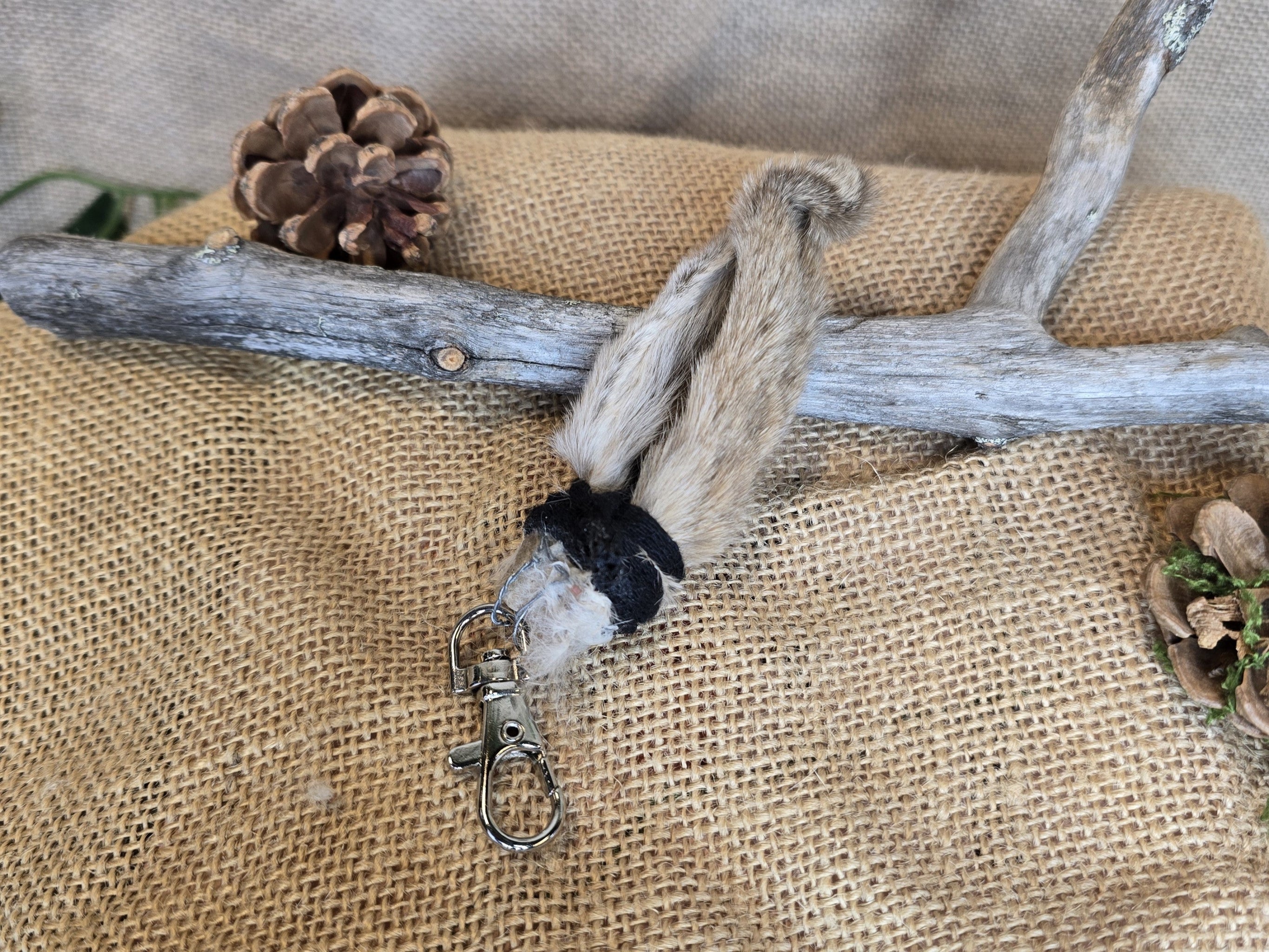 Pupunkorva laukkukoru tai avaimenperä, somisteena musta nauha.