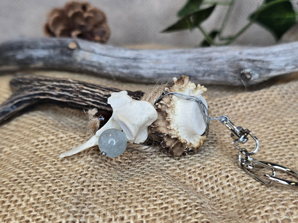 Avaimenperä/ laukkukoru, joka on valmistettu kauriin sarvesta, ketunnikamasta ja sinisestä pitsiakaattihelmestä. 