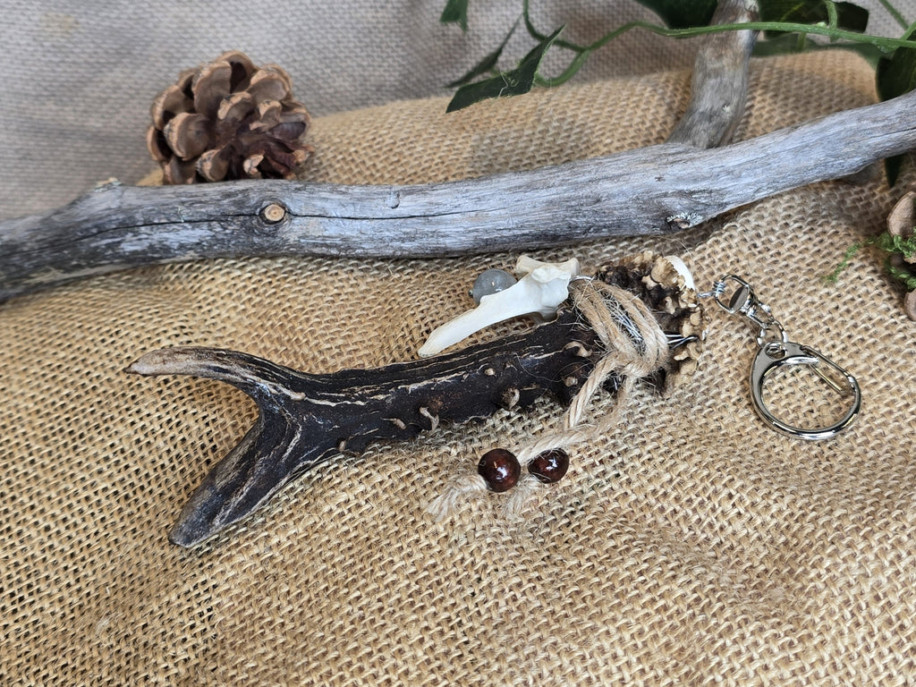 Avaimenperä/ laukkukoru, joka on valmistettu kauriin sarvesta, ketunnikamasta ja sinisestä pitsiakaattihelmestä. 