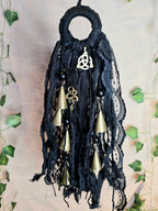 Musta noitakello, jossa kullanväristen kellojen lisäksi käärme ja triquetra symbolit.