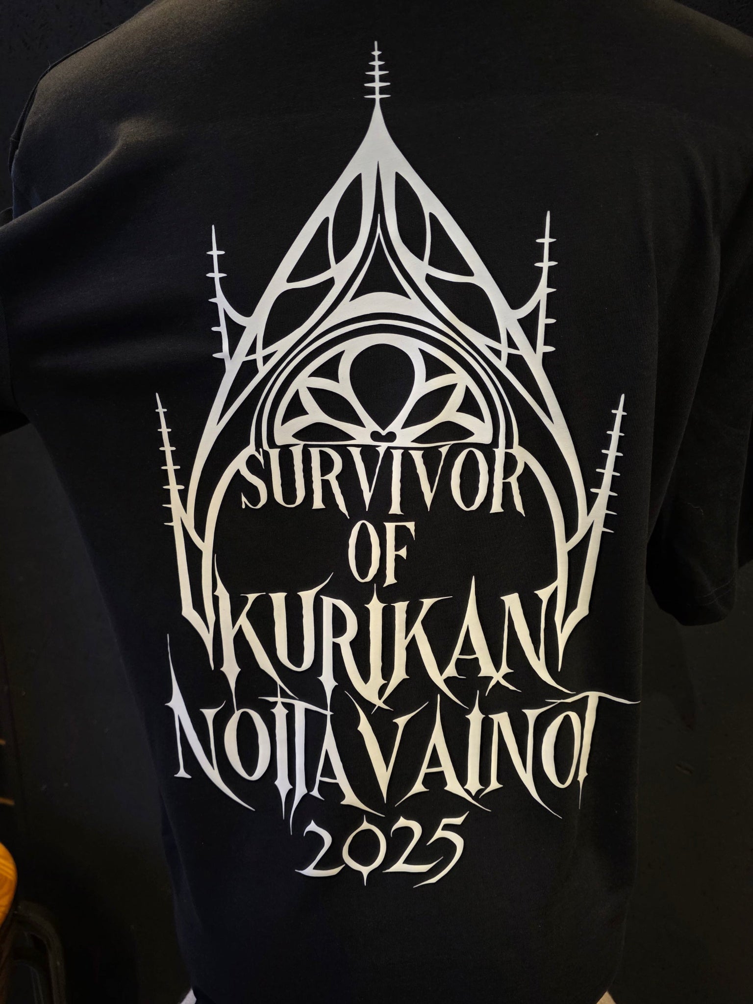 Inked Mystiqs Kurikan noitavainot 2025, musta t-paita, unisex malli. Painatus edessä ja takana.