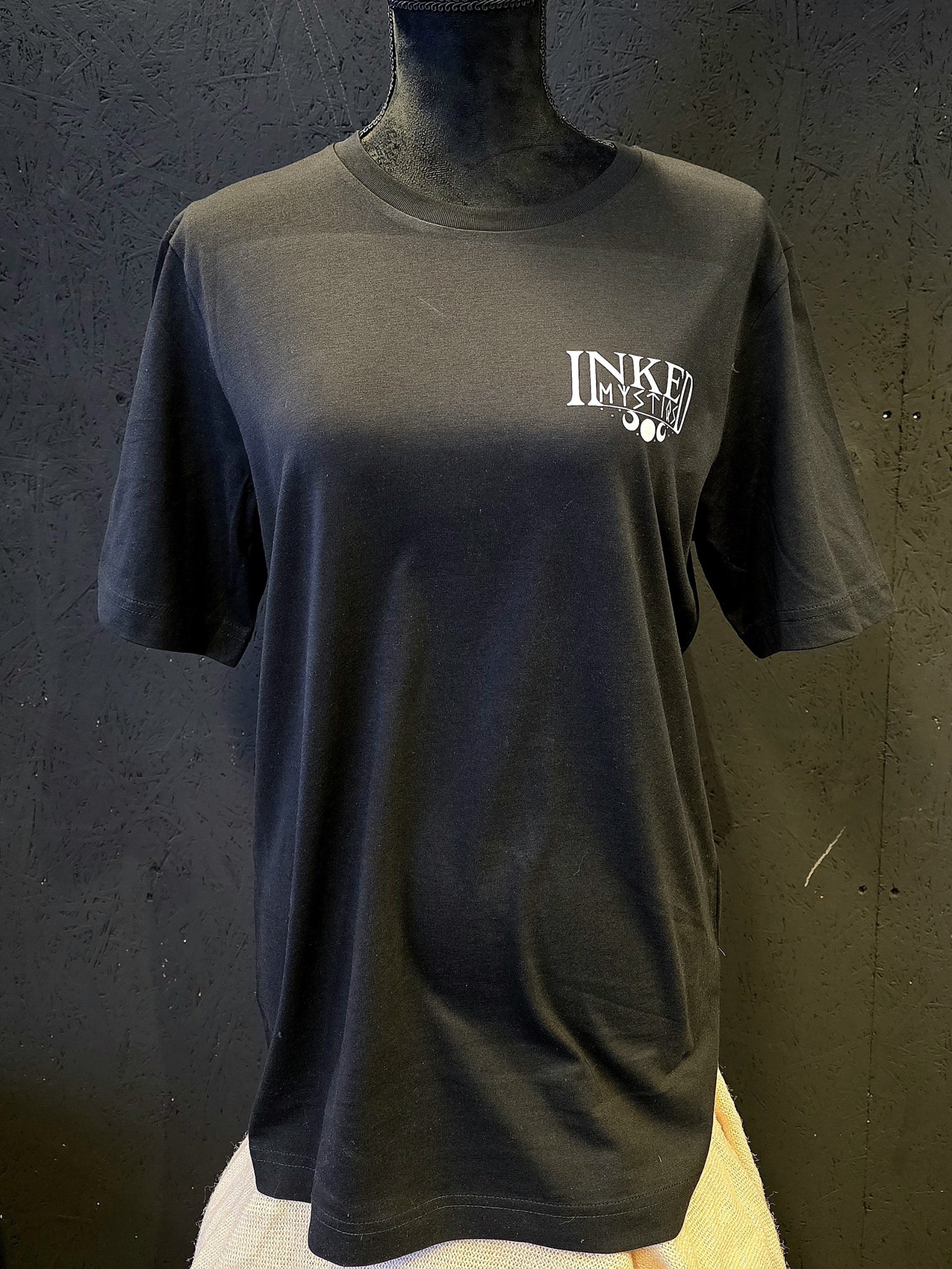 Inked Mystiqs Kurikan noitavainot 2025, musta t-paita, unisex malli. Painatus edessä ja takana. 