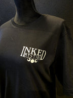 Inked Mystiqs Kurikan noitavainot 2025, musta t-paita, unisex malli. Painatus edessä ja tak