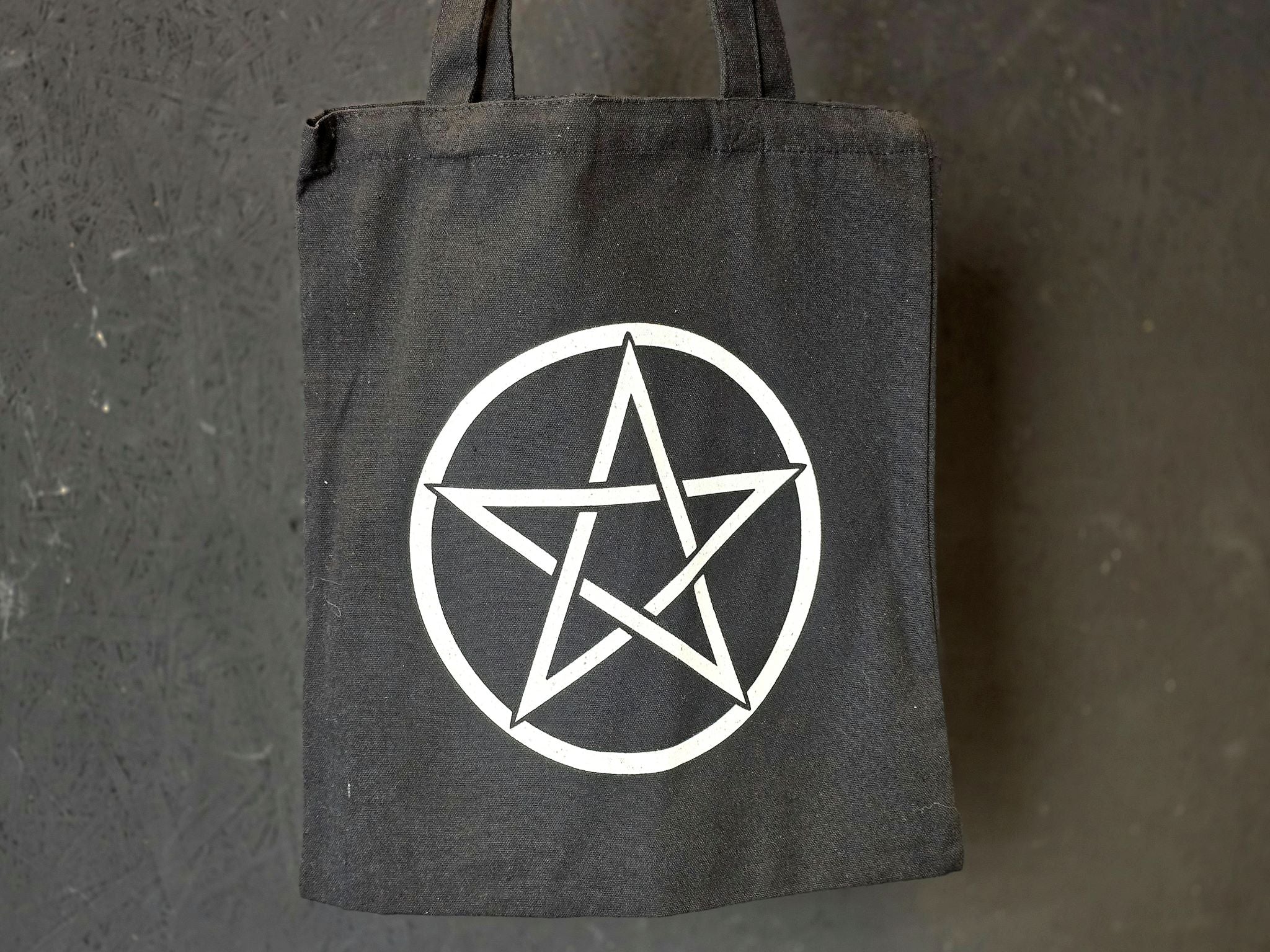 Musta kangaskassi pentagram symbolilla.