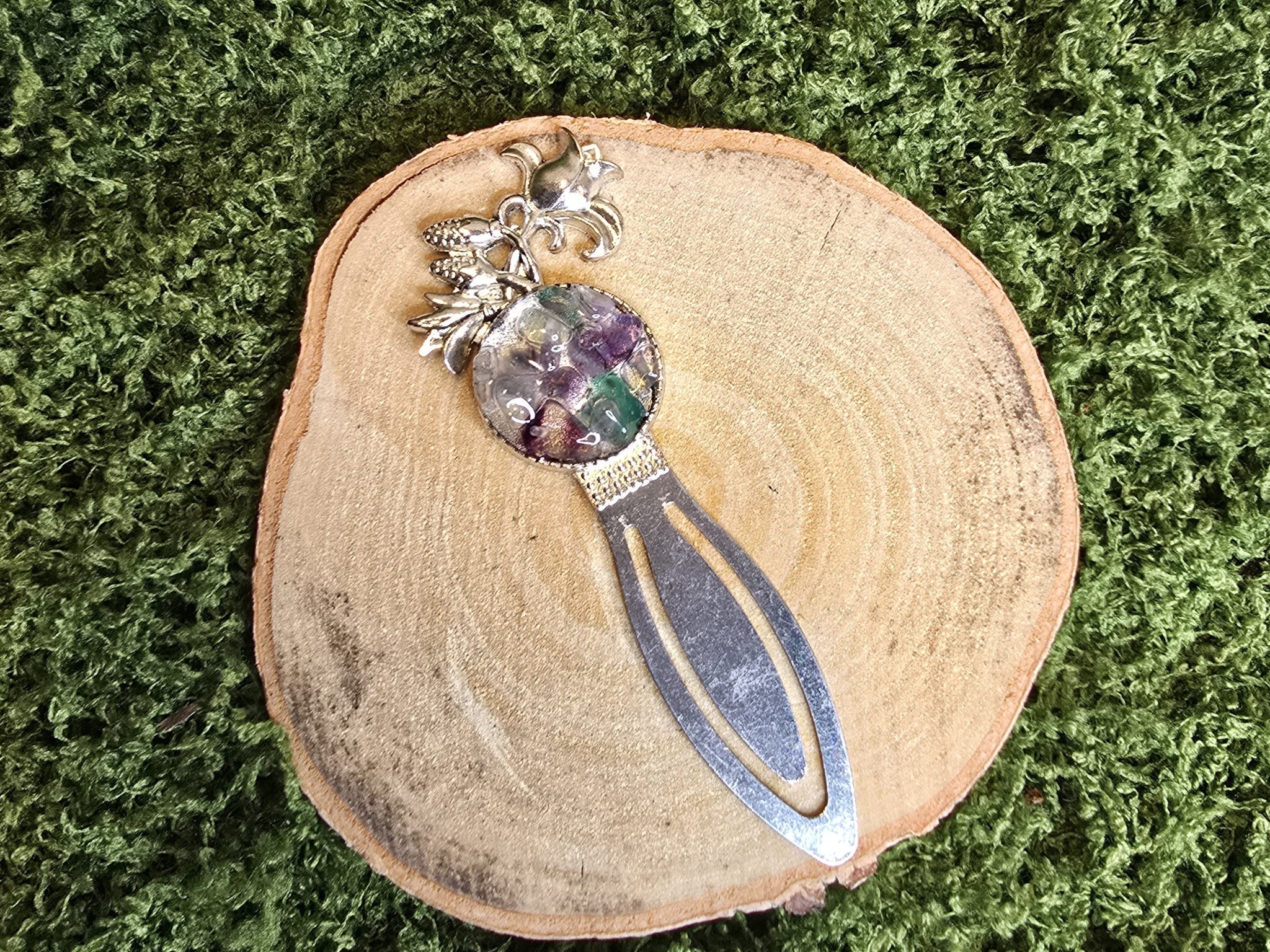 Kirjanmerkki, jossa fluoriittisiruista amuletti. 