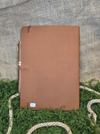 Ruskea muistikirja vegvisir symbolilla ja kynällä takaa.