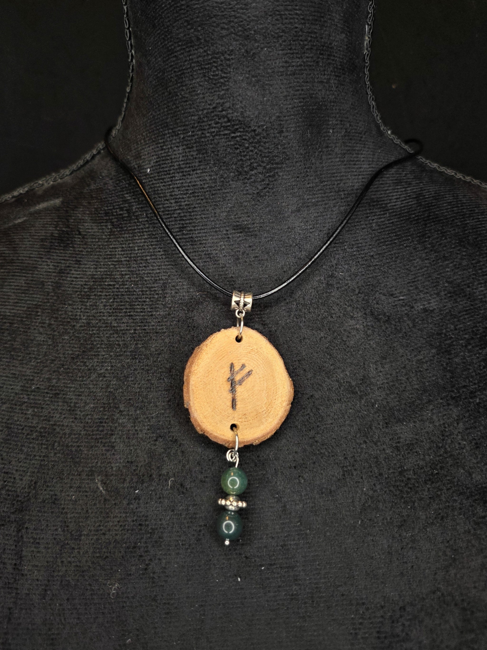 Kaulakoru, jossa on puusta valmistettu riimu amuletti, sammalakaatti helmillä. 