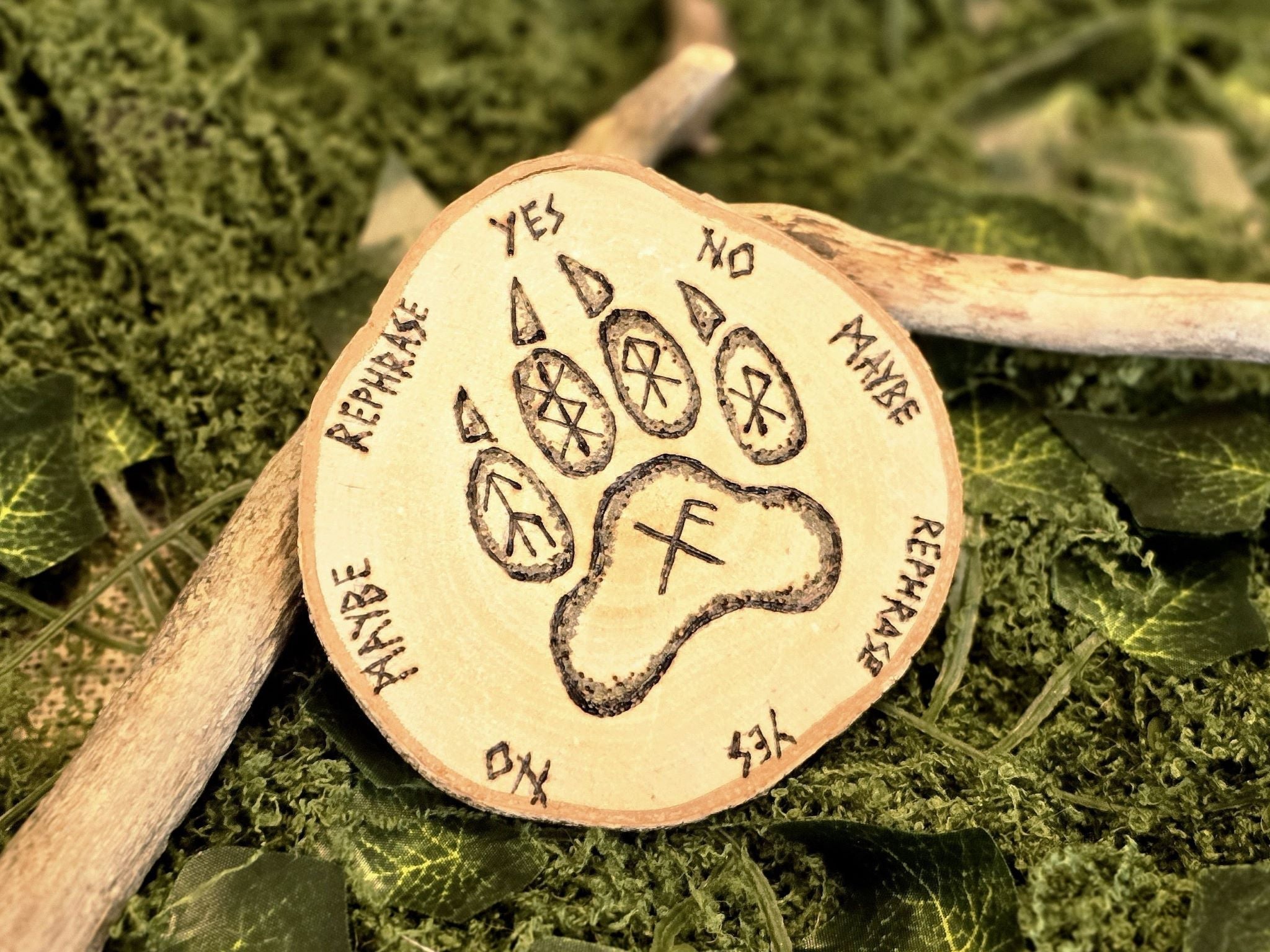 Kaunis puukiekkoon kuvioitu heilurialusta, tassunjäljellä jossa riimuja. 