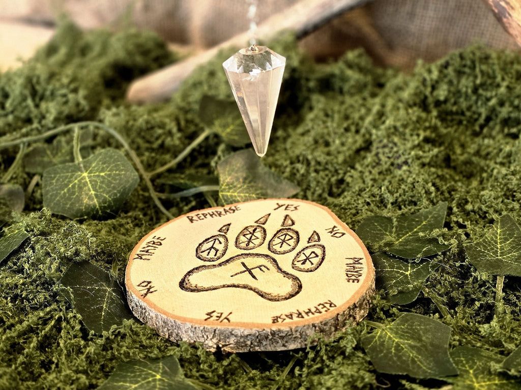 Kaunis puukiekkoon kuvioitu heilurialusta, tassunjäljellä jossa riimuja. 