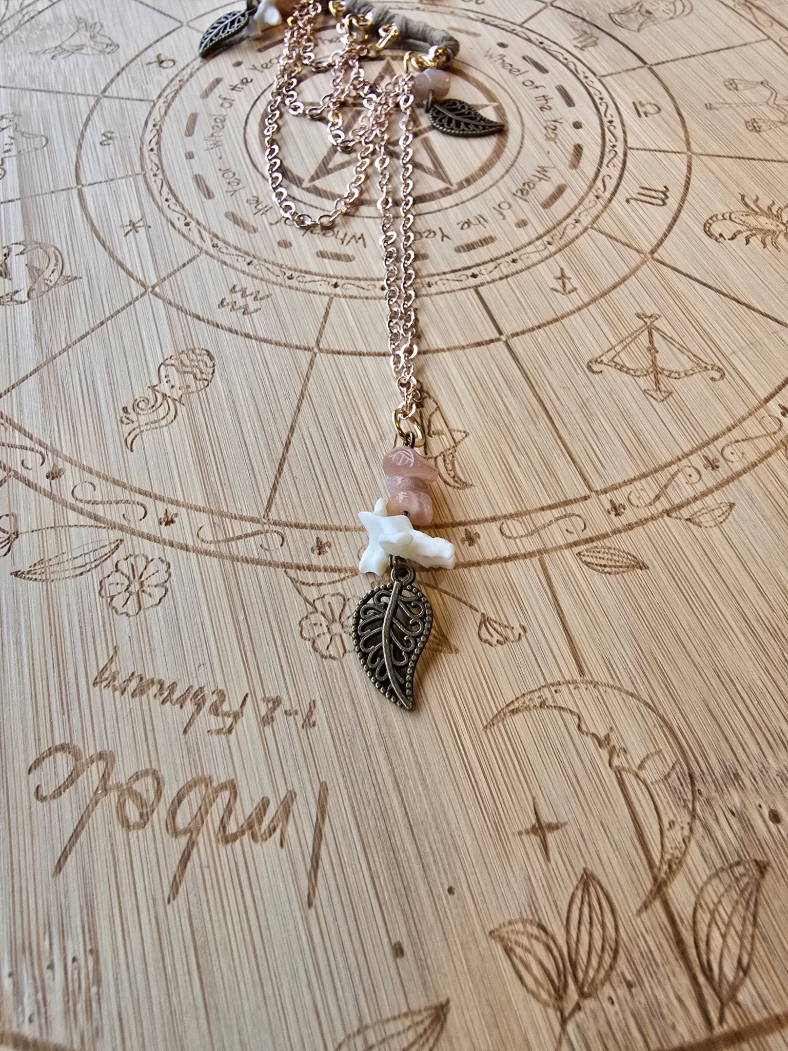 Korvakääty, ruusukultaiset ketjut, rodoniittisirut, lehti somisteet, naakannikamaluu. Kuunjuurella valmistama upea koru.