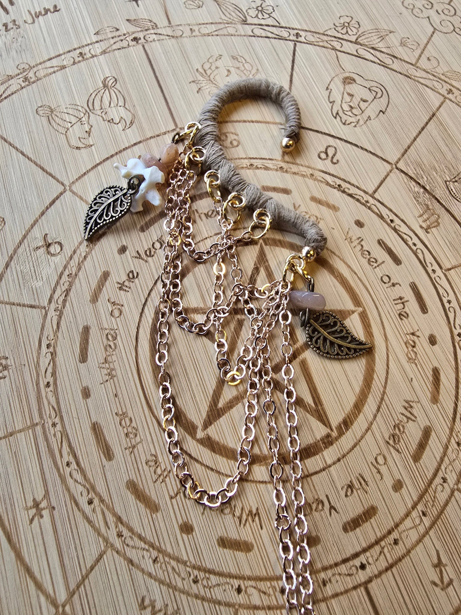 Korvakääty, ruusukultaiset ketjut, rodoniittisirut, lehti somisteet, naakannikamaluu. Kuunjuurella valmistama upea koru.