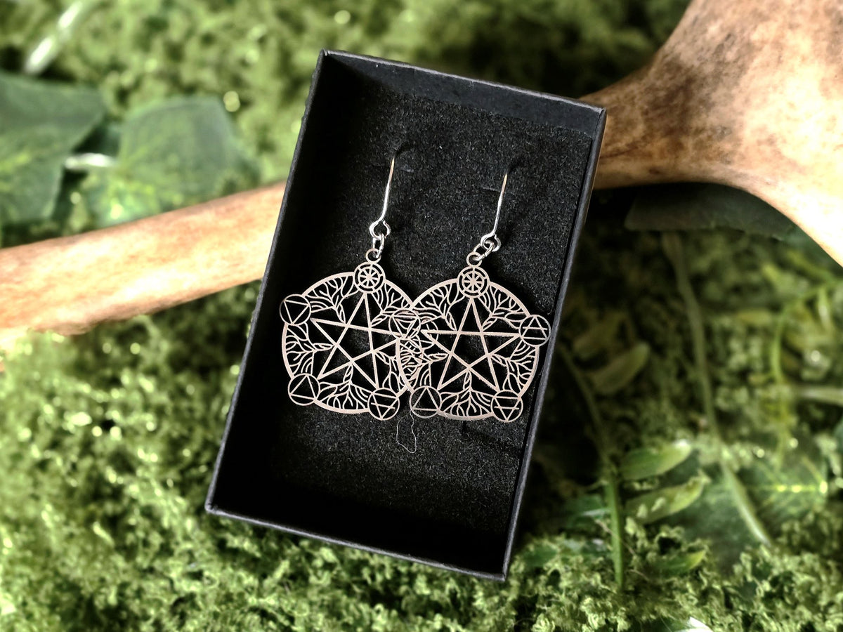 Pentagram aiheiset koristeelliset korvakorut, joissa kuvattu elementtien tasapaino.