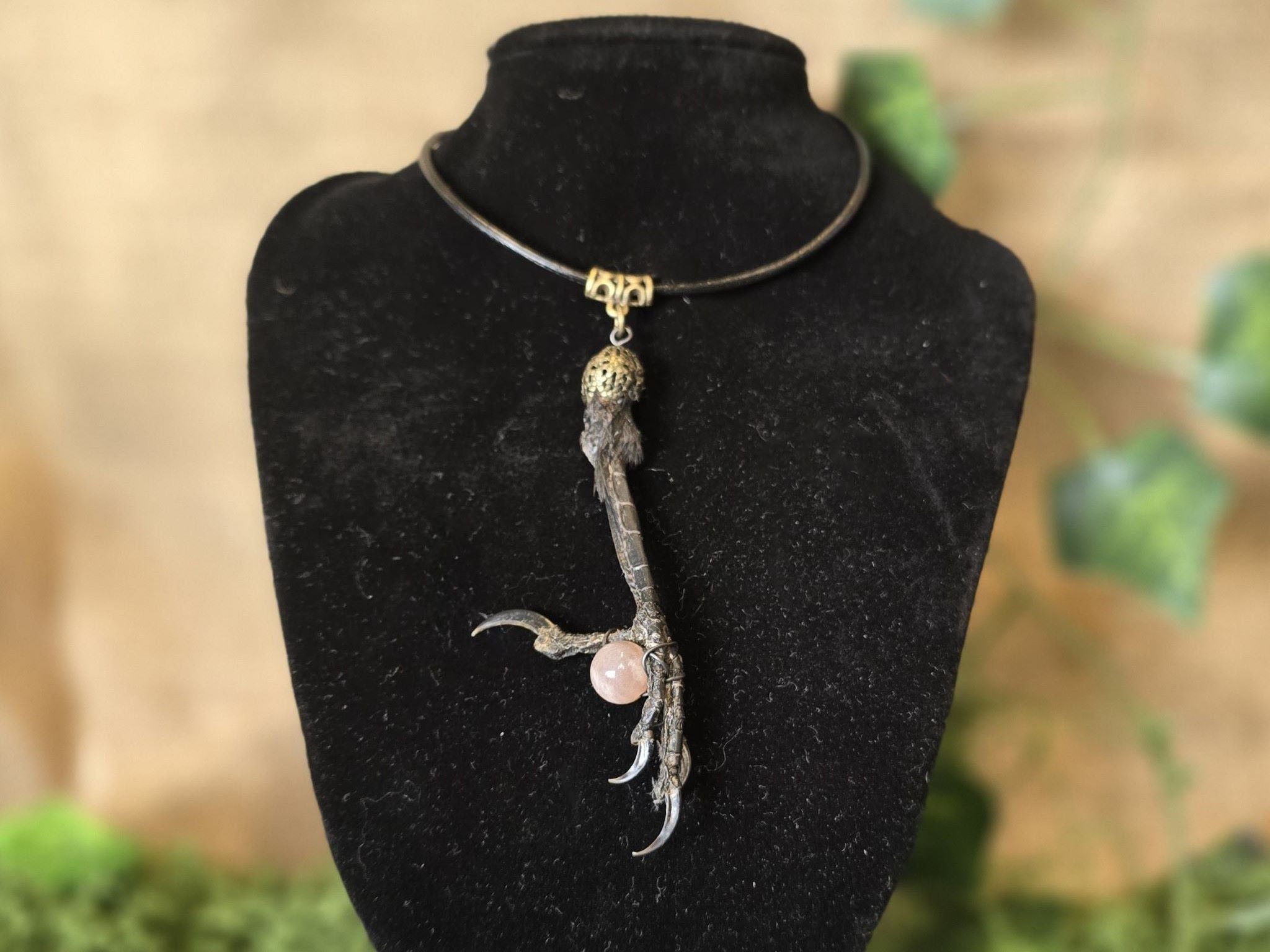 Kuunjuurella valmistama uniikki kaulakoru Varis & aurinkokivi, jossa variksen jalka pitelee aurinkokivi helmeä. Inked mystiqs noitakaupasta!