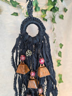 Musta Noitakello, jossa pentagram ja avain symboli, viisi ruosteenpunaista kelloa. 