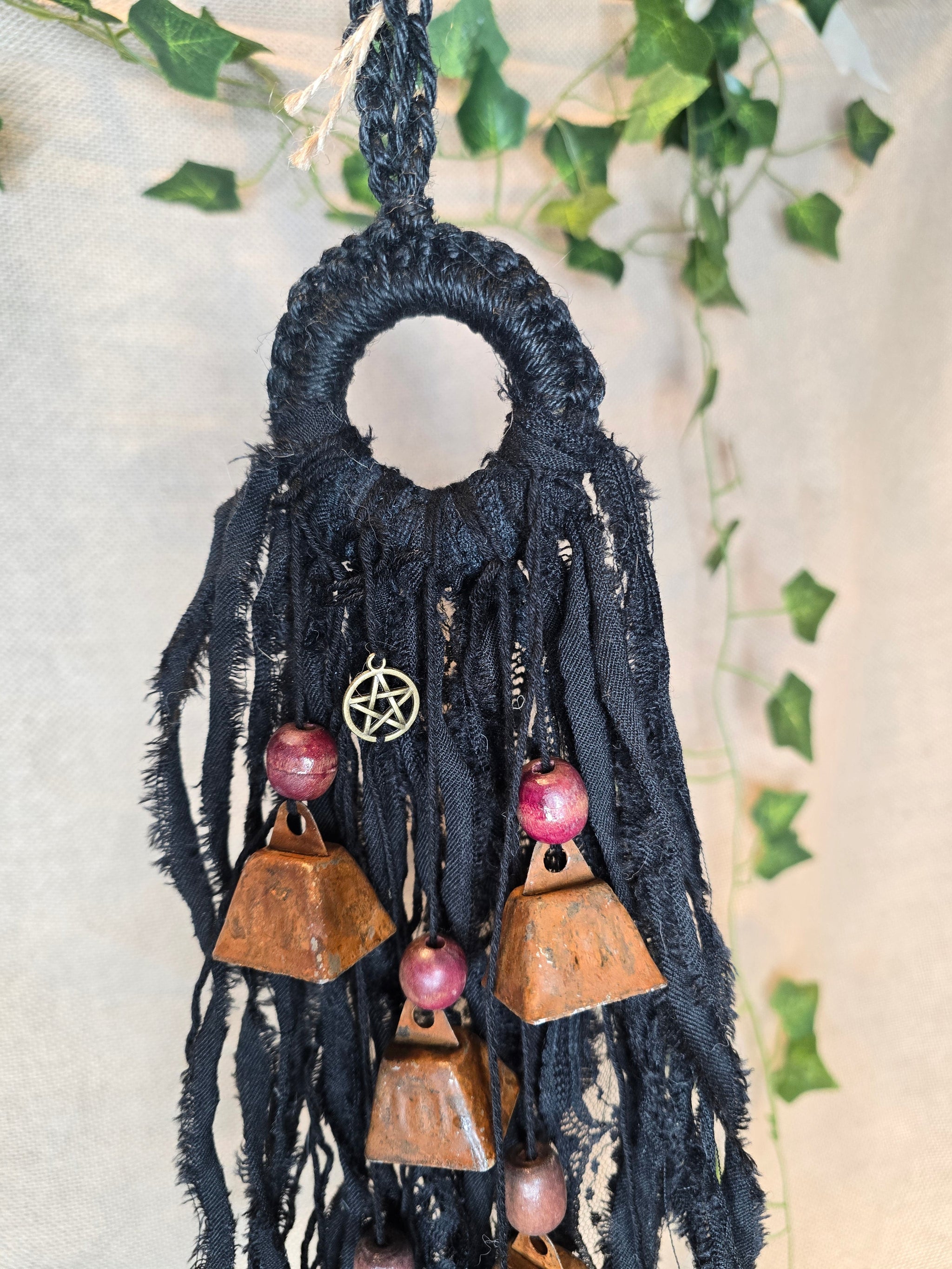 Musta Noitakello, jossa pentagram ja avain symboli, viisi ruosteenpunaista kelloa. 