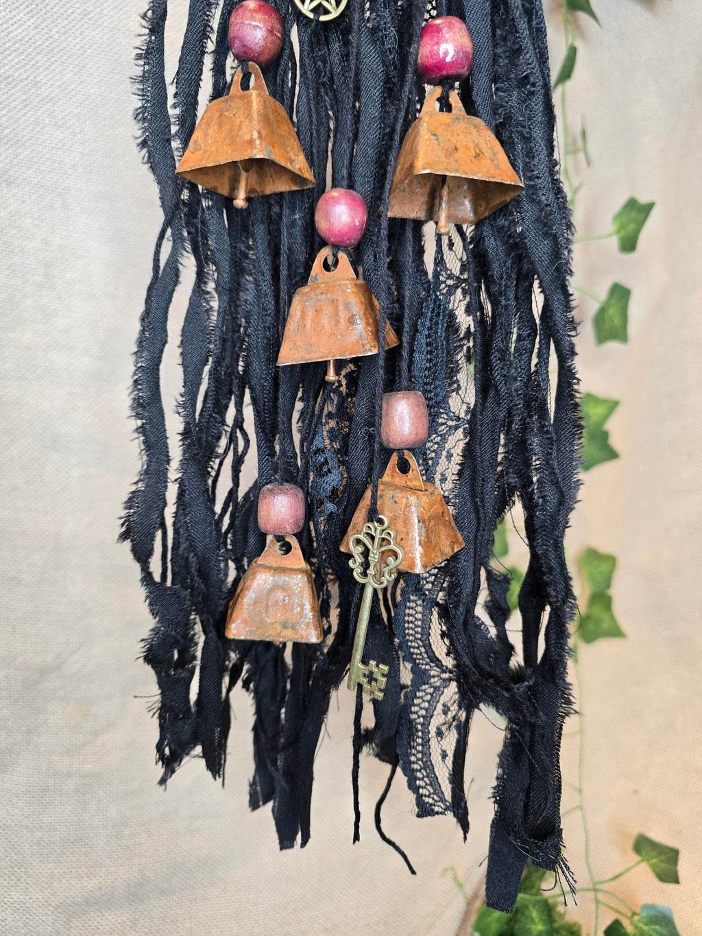 Musta Noitakello, jossa pentagram ja avain symboli, viisi ruosteenpunaista kelloa. 