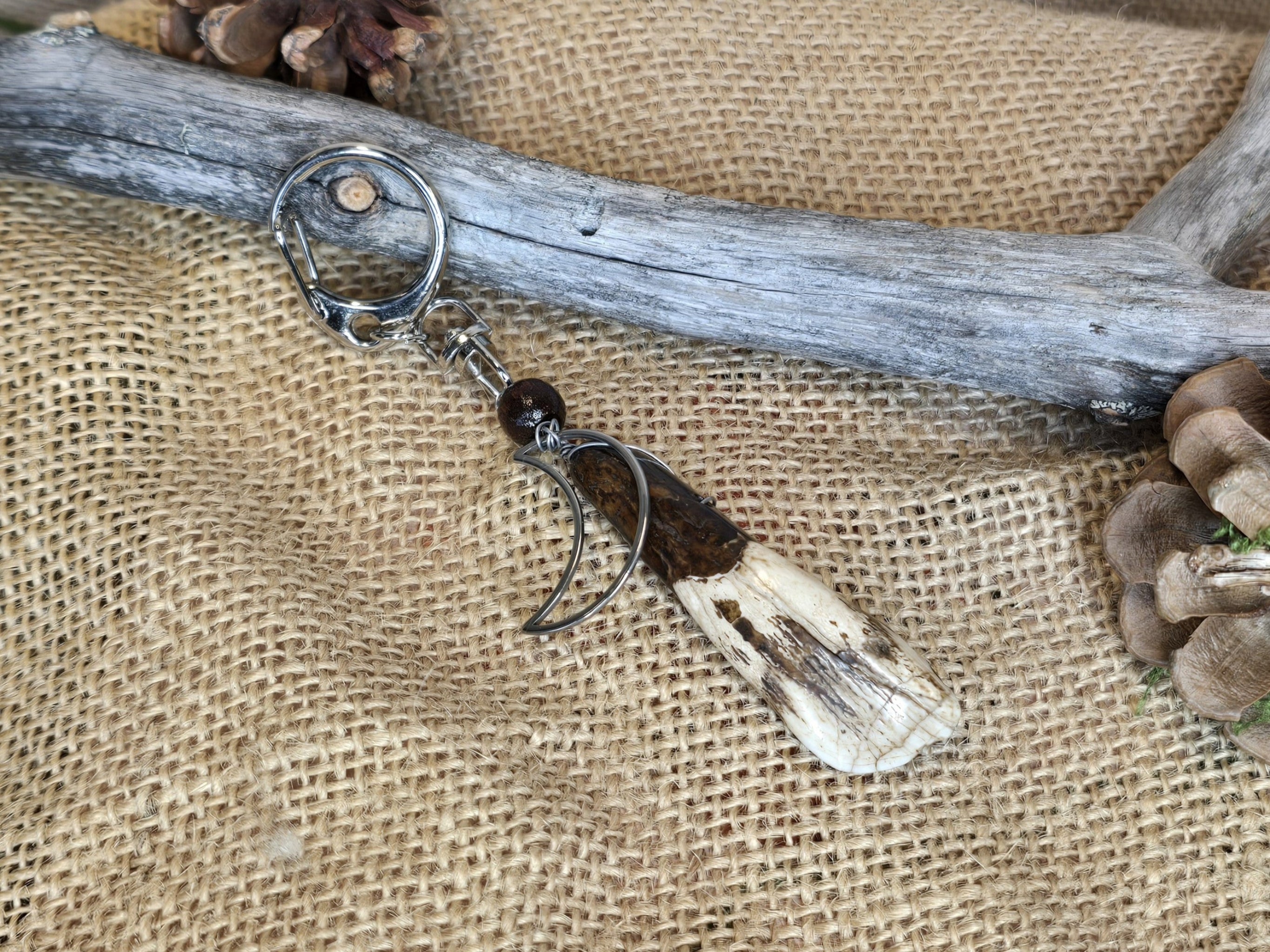 Avaimenperä tai laukkukoru, jossa vesipuhvelin hammas ja kuuriipus. 