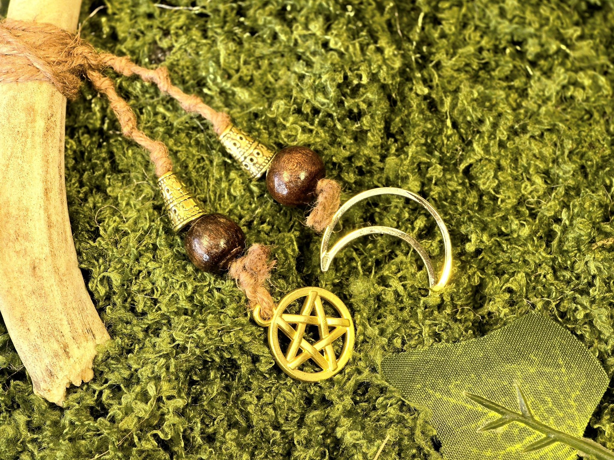 Porosarvesta valmistettu rituaalisoitin, kultaiset kellot, pentagram, noidansolmu ja kuusymboli.