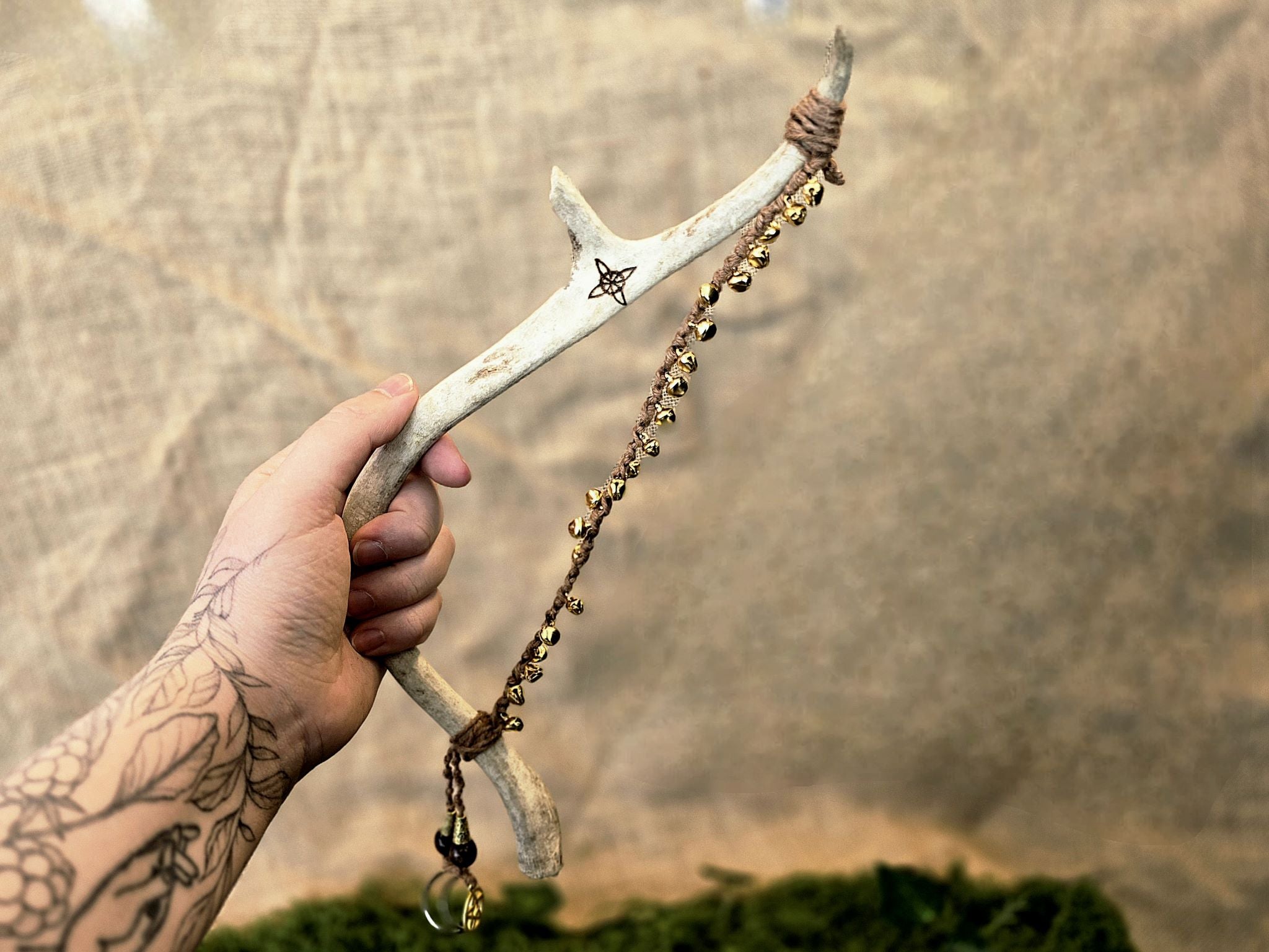 Porosarvesta valmistettu rituaalisoitin, kultaiset kellot, pentagram, noidansolmu ja kuusymboli.